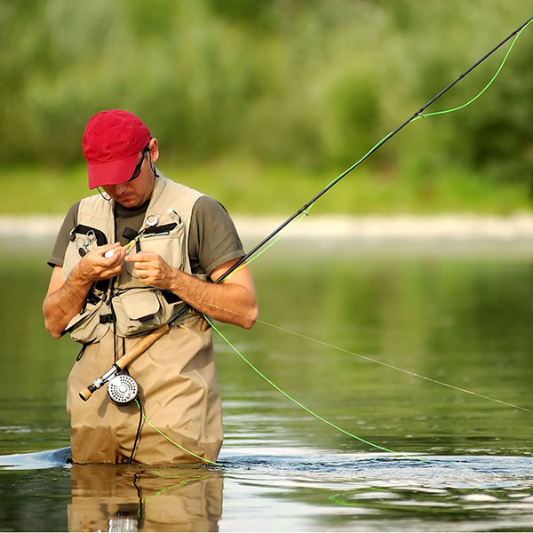 Man fly fishing and tying a lure