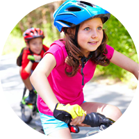 Young boy and girl biking with helmets on