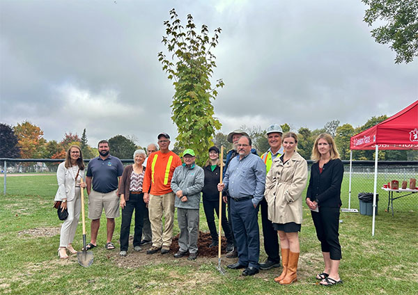a group of people standing in front of a tree for a photo